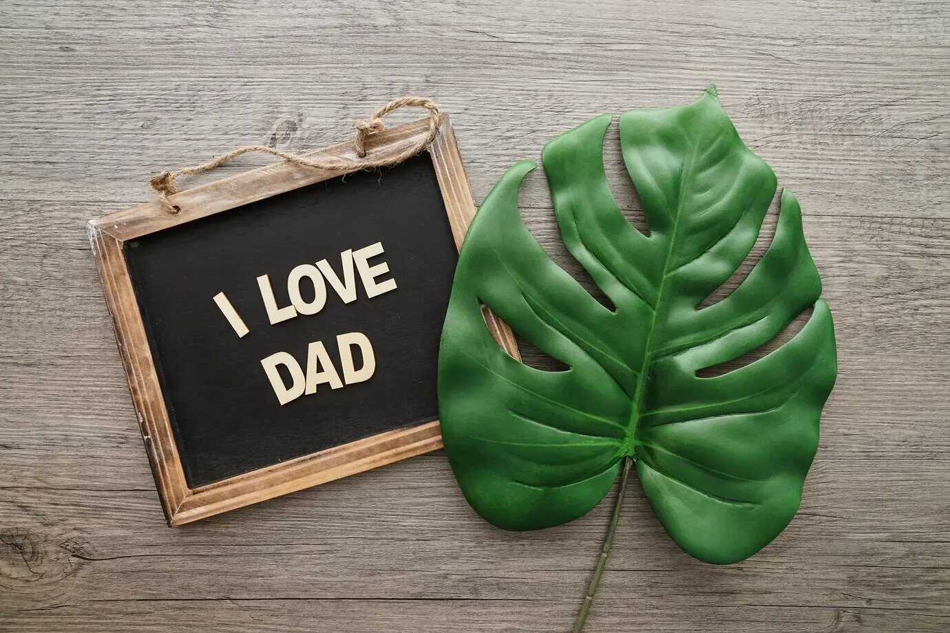 Adorable arrangement with a palm leaf and a slate for Father’s Day.