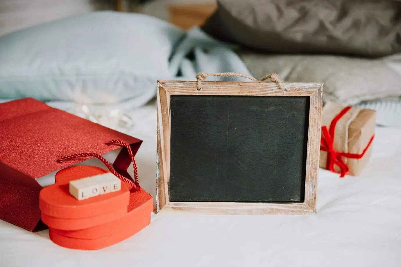 A blackboard next to a paper bag and presents.